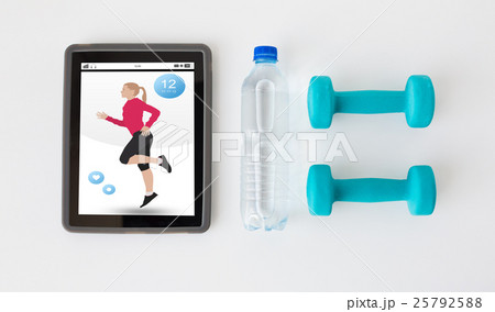 close up of tablet pc, dumbbells and water bottle close up of tablet pc, dumbbells and water bottle 25792588