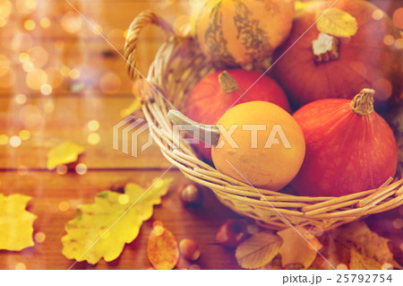 close up of pumpkins in basket on wooden table close up of pumpkins in basket on wooden table 25792754