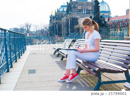 Woman tourist writes his impressions in Woman tourist writes his impressions in 25799001
