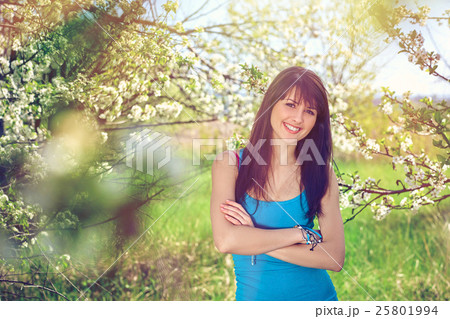 Woman smiling standing in blooming trees in spring Woman smiling standing in blooming trees in spring 25801994
