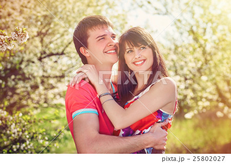 Young couple enjoying in blooming garden Young couple enjoying in blooming garden 25802027