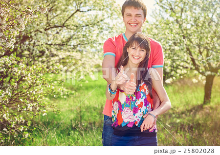 Young couple enjoying in blooming garden Young couple enjoying in blooming garden 25802028