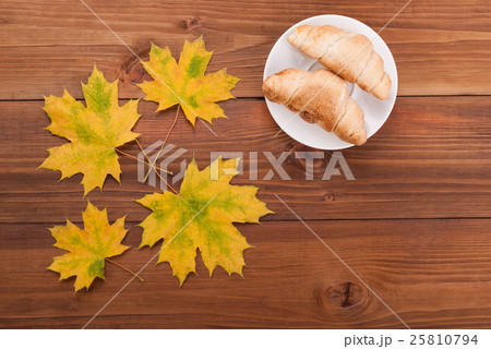 Croissants and maple leaves on wooden background. Croissants and maple leaves on wooden background. 25810794