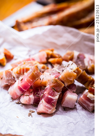 Raw smoked bacon slices on wooden board with cumin 25823613