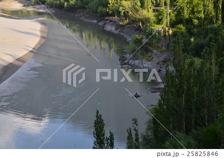 パキスタン　スカルドゥ　インダス川といかだを漕ぐ男性 25825846