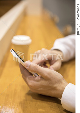 カフェでスマホ操作 25829823