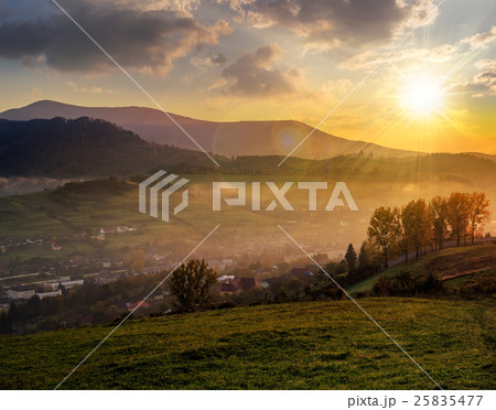 meadow near village in autumn mountains at sunset 25835477