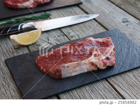 Raw beef steak on dark wooden table background Raw beef steak on dark wooden table background 25858982