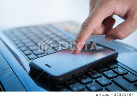finger holding to phone on keyboard 25861737