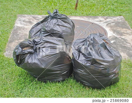 Black garbage bag on grass field Black garbage bag on grass field 25869080