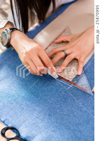 Detail of hands with scissors at tailor shop  25870995