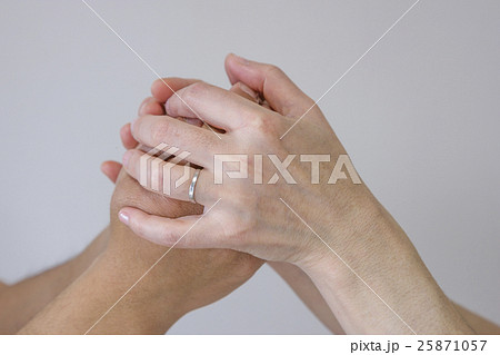 男性の手を包み込む女性の手の写真素材