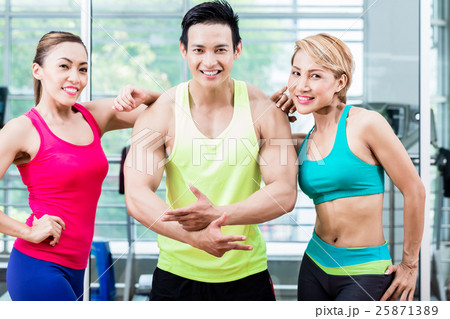 Muscular man amongst two sportive women  25871389
