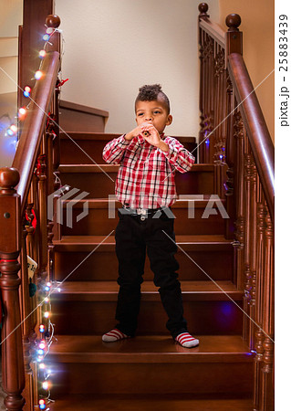 Standing black kid plays flute.  25883439