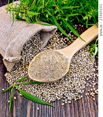 Flour hemp in spoon with leaf and bag on board Flour hemp in spoon with leaf and bag on board 25885201