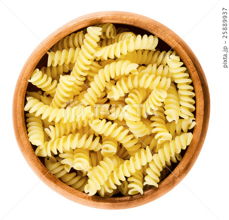 Girandole torsades pasta in wooden bowl over white 25889937