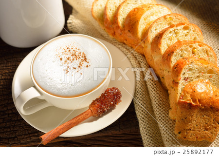 Coffee cup and bread on wooden background Coffee cup and bread on wooden background 25892177