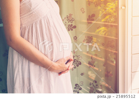 close up hand pregnant woman holding tummy 25895512