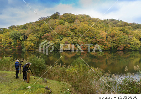 早朝の十二湖の落口の池を撮影するカメラマン 25896806