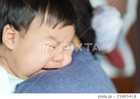 Adorable baby girl cry on mom shoulder. 25905418