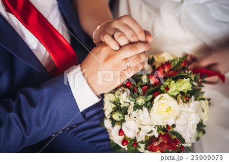hands of bride and groom on the bouquet hands of bride and groom on the bouquet 25909073