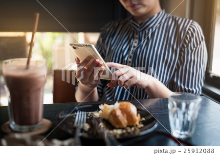 Woman using phone in cafe 25912088