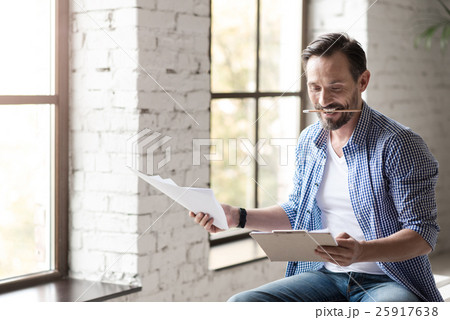 Attractive positive man clenching a pencil in his Attractive positive man clenching a pencil in his 25917638