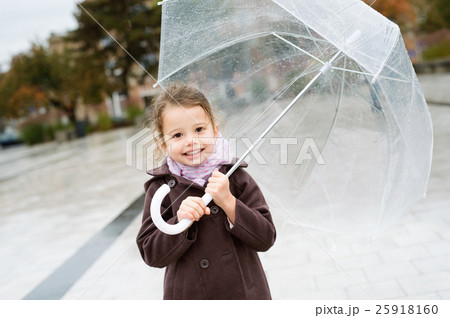 Little girl under the transparent umbrella outside Little girl under the transparent umbrella outside 25918160