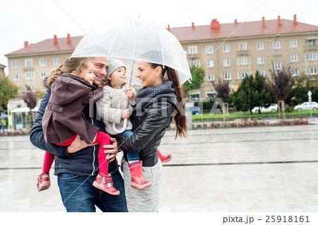 Young family with two daughters under the umbrella Young family with two daughters under the umbrella 25918161