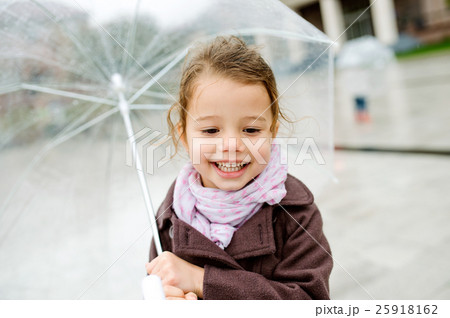 Little girl under the transparent umbrella outside 25918162
