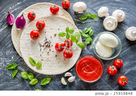 Pizza ingredients on the dark wooden background Pizza ingredients on the dark wooden background 25919848