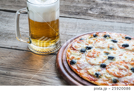 Cooked pizza with a glass of beer 25920086