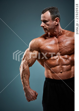 torso of attractive male body builder on gray 25920418