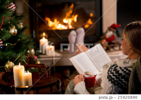 Woman is sitting with cup of hot drink and book 25920890