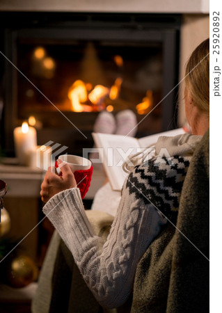 Woman is sitting with cup of hot drink and book 25920892