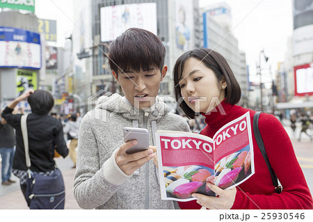 カップル　男女　東京観光　デート　渋谷スクランブル交差点　ガイドブックを手に　スマホで検索 25930546