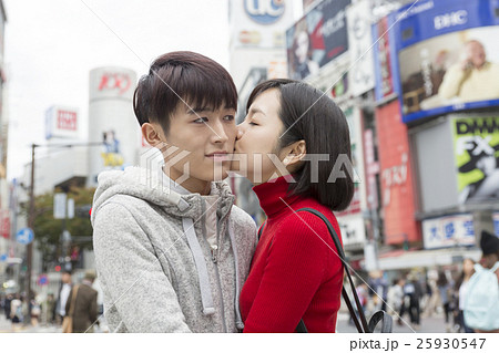 カップル 男女 デート 渋谷スクランブル交差点でほっぺにキスをする恋人 幸せ スキンシップの写真素材 25930547 Pixta