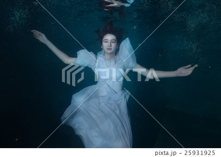 Woman in a white dress under water. Woman in a white dress under water. 25931925