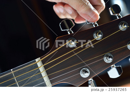 Hand tuning a guitar from headstock 25937265