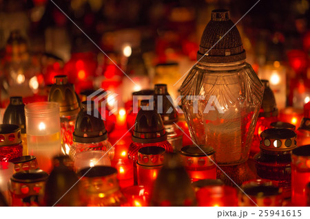 Many burning candles in the cemetery at night. 25941615