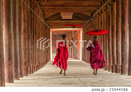 Back side of two young monk holding the traditional umbrella on the Mya Thein Tan Pagoda at bagan, mandalay, myanmar Buddhist novice are walking in pagoda,myanmar Back side of two young monk holding the traditional umbrella on the Mya Thein Tan Pagoda at bagan, mandalay, myanmar Buddhist novice are walking in pagoda,myanmar 25944588
