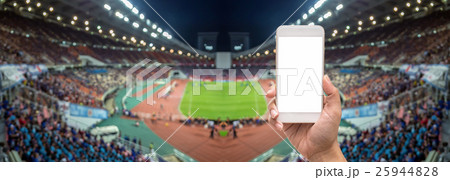 Female hand holding mobile smart phone touch screen on Panorama of Abstract blurred photo of fan sport at stadium, sport background concept 25944828