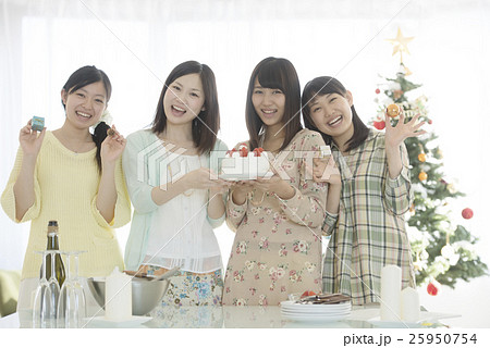 ケーキとクリスマスグッズを持ち微笑む4人の女性 ケーキとクリスマスグッズを持ち微笑む4人の女性 25950754