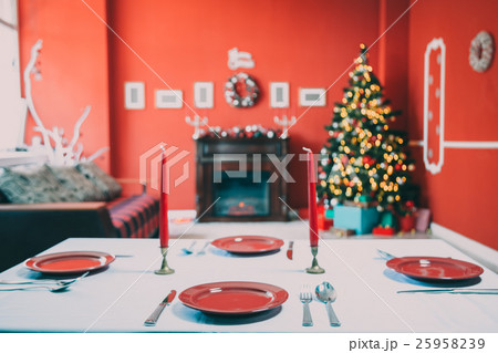 Beautifully laid new year table with red plates Beautifully laid new year table with red plates 25958239