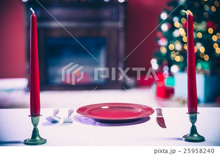 Beautifully laid new year table with red plates Beautifully laid new year table with red plates 25958240