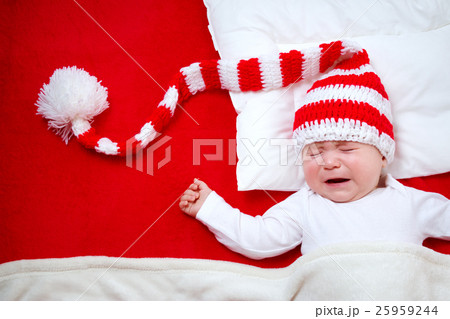 Sleepy baby on red blanket 25959244