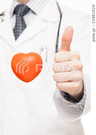 Doctor showing thumb up with toy heart near 25961020