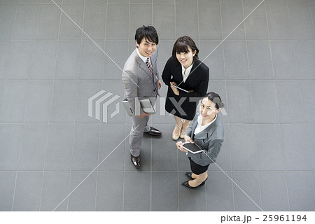 廊下で立ち話をするビジネスマンとビジネスウーマン 俯瞰撮影の写真素材