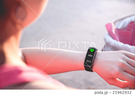 Sporty girl is looking on her smartwatch 25962932