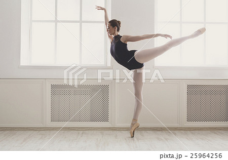 Beautiful ballerine stands in arabesque ballet 25964256